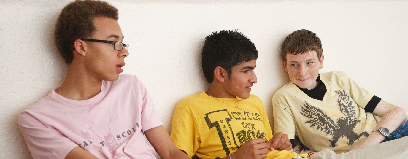 Three teenagers sitting on a sofa. 