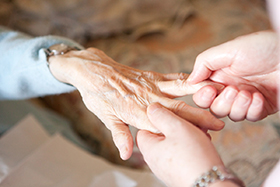 Picture of someone massaging an old persons hand